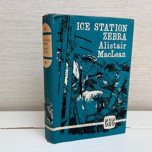 May include: Vintage hardcover book titled "Ice Station Zebra" by Alistair MacLean. The book has a teal cover with illustrations of men and machinery. The spine features the title and author's name in white.