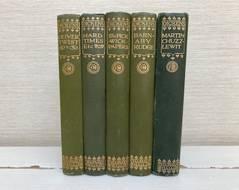 May include: A set of six green hardcover books with gold lettering. The titles are "Oliver Twist", "Hard Times", "The Pickwick Papers", "Barn-Abey Rudge", and "Martin Chuzzlewit".
