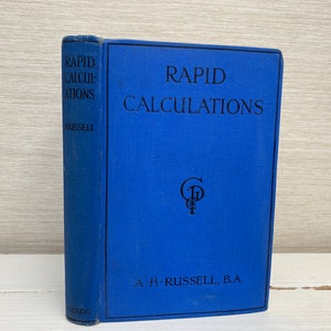 Puede incluir: Un libro de tapa dura azul titulado "Rapid Calculations" de A.H. Russell, B.A. El libro tiene un símbolo en relieve dorado en la portada.