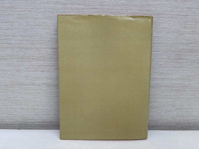 May include: A rectangular, olive-green object with a slightly textured surface. The object is positioned vertically against a light gray, wood-grain background. The bottom edge rests on a white surface.