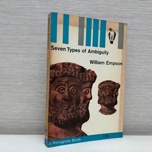 May include: A blue and white book titled "Seven Types of Ambiguity" by William Empson. The cover features two brown, sculpted faces.