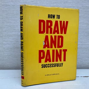 May include: A yellow book with the title "How to Draw and Paint Successfully" in red and black text. The book is by K.A. Box and C.R. Apple, R.I.P.A.