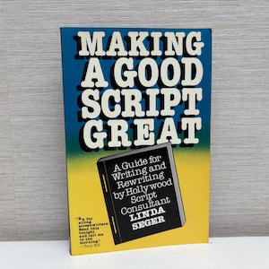Puede incluir: Un libro amarillo y azul titulado "Making a Good Script Great" con el subtítulo "A Guide for Writing and Rewriting by Hollywood Script Consultant Linda Seger".