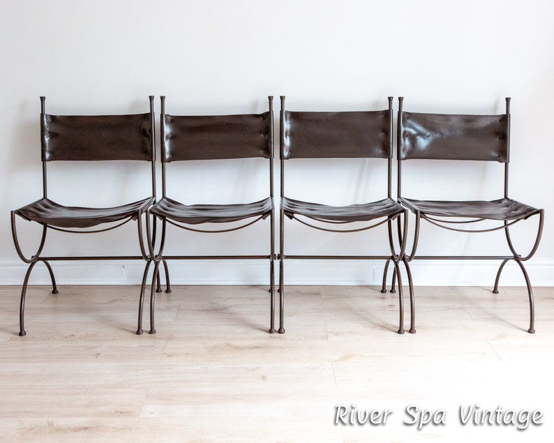 May include: Four brown leather chairs with metal frames. The chairs are arranged in a row and have a simple, rustic design.