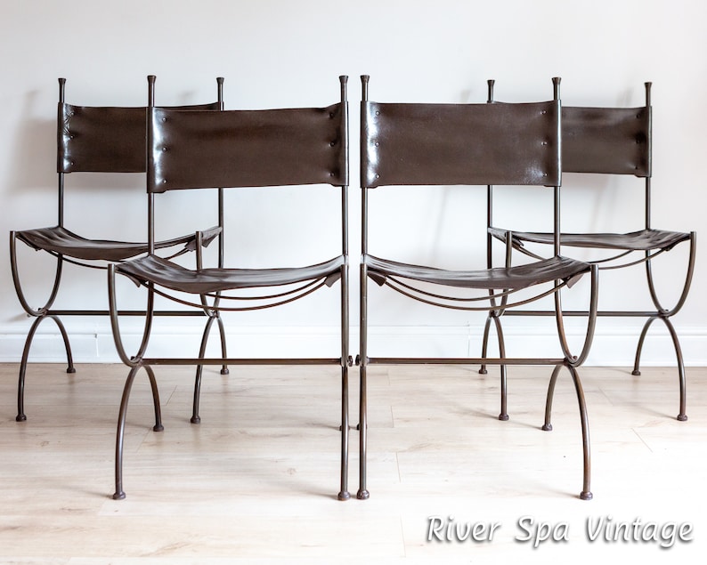 May include: Four brown leather chairs with metal frames. The chairs are arranged in a row, facing the camera. The chairs have a simple, rustic design.