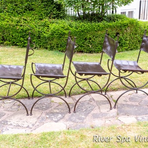 May include: Four brown leather chairs with metal frames. The chairs are arranged in a row on a stone patio.