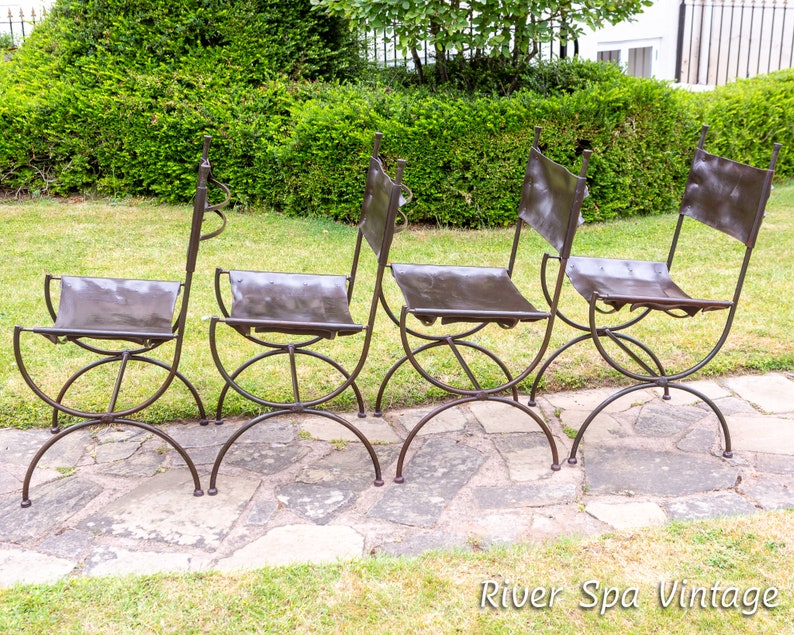 May include: Four brown leather chairs with metal frames. The chairs are arranged in a row on a stone patio.