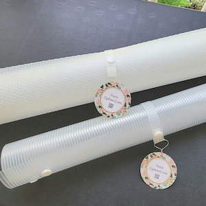 Puede incluir: Dos tapetes para hornear de silicona blanca enrollados con etiquetas con estampado floral que dicen "Feliz Día de la Abuela".