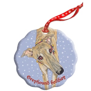 May include: A ceramic Christmas ornament featuring a Greyhound dog with a red and white collar with bells. The ornament is a light blue color with white snowflakes and the text "Greyhound Holiday".