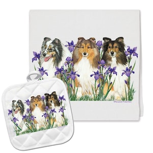 May include: A white kitchen towel and matching pot holder feature a colorful illustration of four Shetland Sheepdogs sitting in a field of purple irises. The text "Sprigware Productions" is printed on the towel.