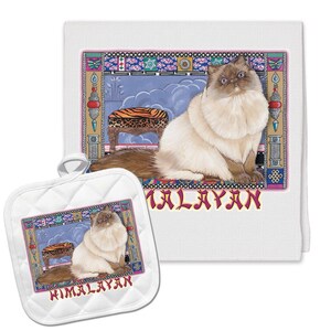 May include: A white kitchen towel and matching pot holder feature a colorful illustration of a Himalayan cat sitting on a patterned stool. The text "HIMALAYAN" is printed in pink below the image.