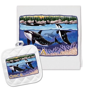 May include: A white kitchen towel and matching pot holder with a colorful illustration of orcas swimming in the ocean. The illustration features a pod of orcas swimming in a blue ocean with coral reefs and bubbles. The text "ORCA" is printed on the pot holder.