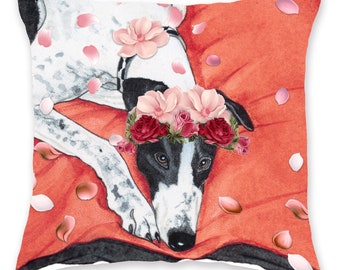 May include: A black and white dog with a flower crown on its head is lying on a red pillow with pink flower petals scattered around it.