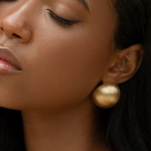 chunky gold earrings on a model