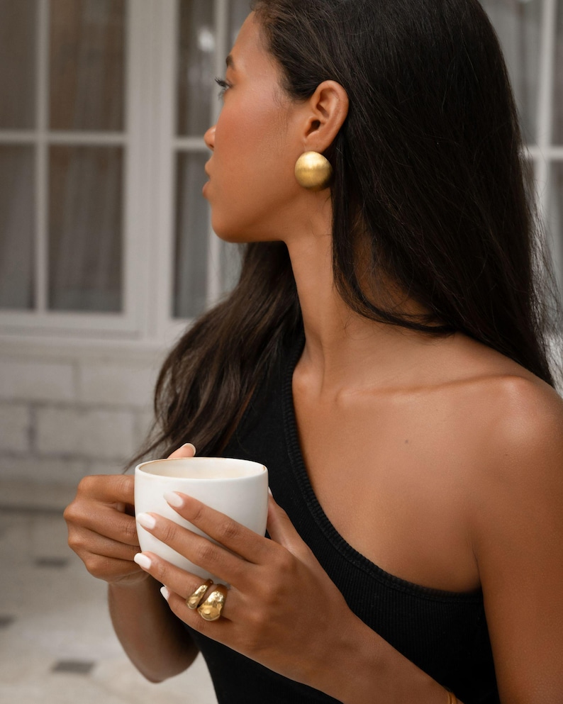 a model wearing a 18k gold plated large earrings