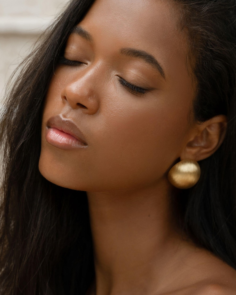 chunky gold earrings on a model
