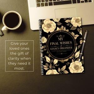 May include: A spiral-bound "My Final Wishes & Legacy Organizer" notebook with a black cover adorned with cream-colored floral designs. A pen rests beside the notebook, and a laptop is partially visible.