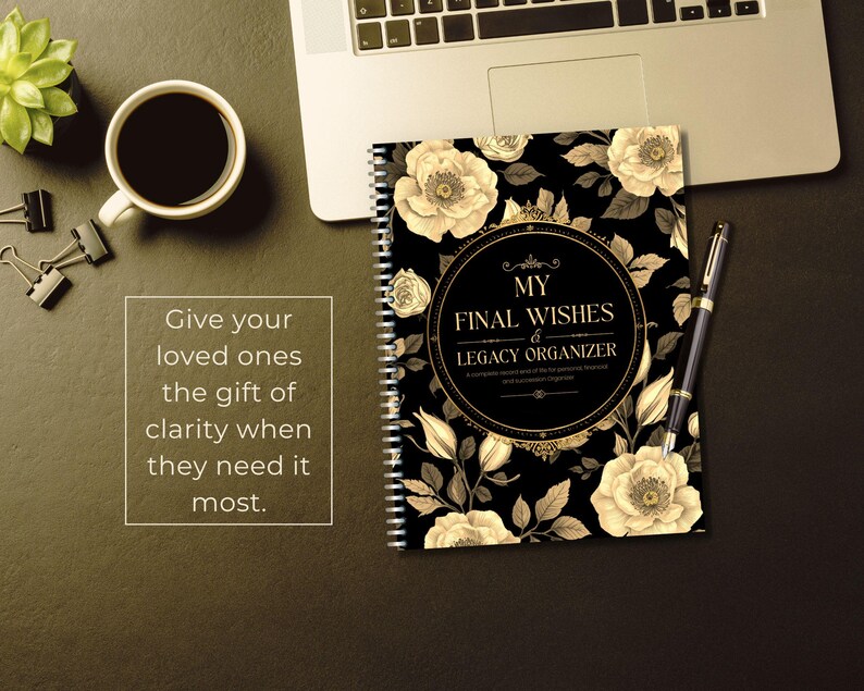 May include: A spiral-bound "My Final Wishes & Legacy Organizer" notebook with a black cover adorned with cream-colored floral designs. A pen rests beside the notebook, and a laptop is partially visible.