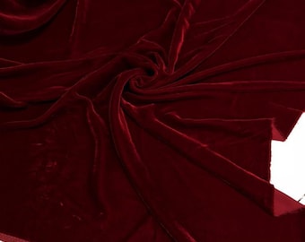 Puede incluir: Un primer plano de una tela de terciopelo rojo oscuro. La tela es suave y lujosa, con un color profundo y rico.