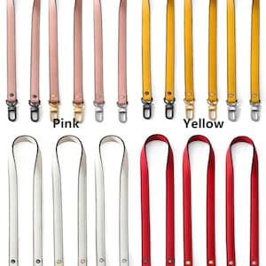 May include: A collection of handbag straps in various colors, including pink, yellow, white, and red. Each strap is long and narrow, with metal clasps at both ends. The word "Pink", "Yellow", "White", and "Red" are printed below the straps.