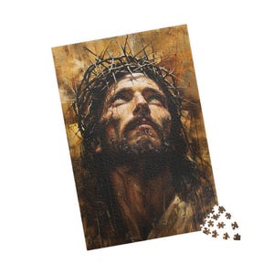 Könnte beinhalten: Ein Puzzle mit einem Porträt eines Mannes mit einer Dornenkrone und einem ernsten Gesichtsausdruck. Das Bild hat einen warmen, sepiafarbenen Hintergrund. Ein paar Puzzleteile sind unten rechts verstreut.