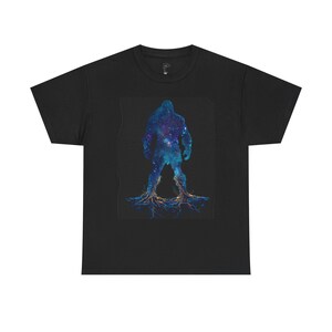Könnte beinhalten: Schwarzes T-Shirt mit einer Grafik einer humanoiden Figur, die mit einem Galaxie-Design gefüllt ist. Die Figur ist in Blau-, Lila- und Weißtönen gehalten, mit wurzelartigen Strukturen an der Basis. Das Design ist mittig auf dem T-Shirt platziert.