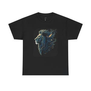 Könnte beinhalten: Schwarzes T-Shirt mit einer detaillierten Illustration des Profils eines Löwen. Der Löwe hat eine blaue Mähne mit goldenen Akzenten und einer Feder. Das Design ist vor einem dunklen Hintergrund. Das Shirt besteht aus einem weichen Material.