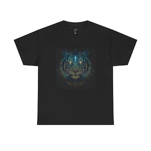 Könnte beinhalten: Schwarzes T-Shirt mit einer detaillierten Illustration eines Tigergesichts. Der Tiger ist in Blau, Grün und Gold dargestellt, mit leuchtend gelben Augen. Das Design ist mittig auf dem Shirt platziert und erzeugt einen auffälligen visuellen Effekt.