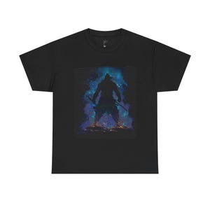 Könnte beinhalten: Schwarzes T-Shirt mit einer Krieger-Silhouette vor einem lebendigen kosmischen Hintergrund aus Blau-, Lila- und Orangetönen. Der Krieger hält zwei Schwerter, was ein dynamisches Bild erzeugt. Das T-Shirt ist aus weichem Material.