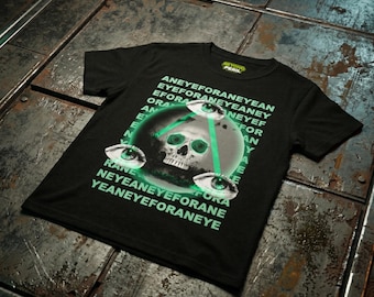 Op de afbeelding: Zwart t-shirt met een grafisch ontwerp met een schedel, drie gloeiende groene ogen en de tekst "ANEYEFORANEYEAN EYEFORANEYEANEY EFORA ORA AN EN RANE NEYEANEYEFORANE YEANEYEFORANEYE".