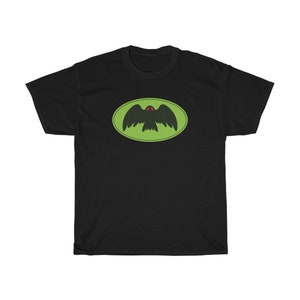 May include: Black t-shirt featuring a green and black bird logo. The bird has red eyes and is flying within a green oval.