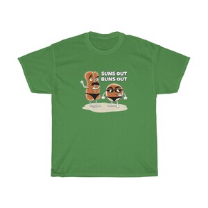 Op de afbeelding: Groen T-shirt met een afbeelding van twee cartoon-broodjes met zonnebrillen en de tekst "Suns Out Buns Out".