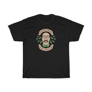May include: Black t-shirt featuring a cartoon illustration of a man with a moustache and glasses. The illustration is surrounded by green dollar bills and a banner that reads "I'd buy that for a dollar!"