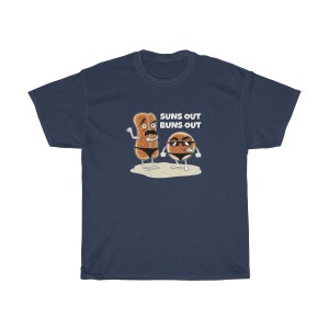 Op de afbeelding: Een marineblauw t-shirt met een afbeelding van twee cartoon-broodjes die een zonnebril dragen en de tekst "Suns Out Buns Out".
