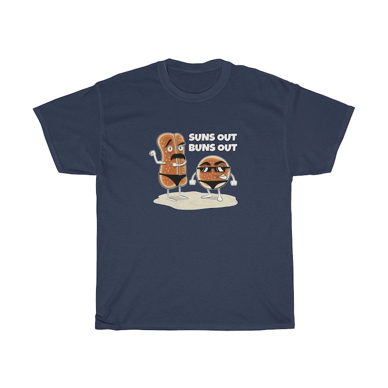 Op de afbeelding: Een marineblauw t-shirt met een afbeelding van twee cartoon-broodjes die een zonnebril dragen en de tekst "Suns Out Buns Out".