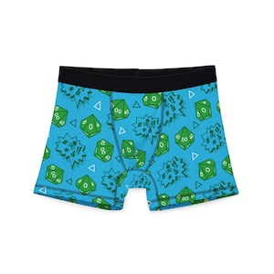 May include: Blue boxer shorts featuring a repeating pattern of green dice, exclamation marks, and triangles. The waistband is black. The dice have the numbers 00 and 40 on them.