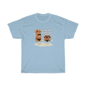Op de afbeelding: Lichtblauw T-shirt met een afbeelding van twee cartoon-broodjes met zonnebrillen en de tekst "Suns Out Buns Out".