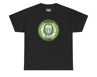 Op de afbeelding: Zwart T-shirt met een cirkelvormige afbeelding met een gestileerd schedelgezicht in een groen en wit ontwerp. De afbeelding bevat de woorden "MEMBER" en "RAATMAIKING CLUB". De tekst "BEYOND PERIL" staat boven de afbeelding.