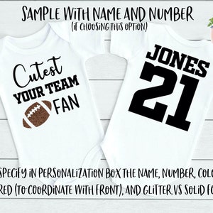 May include: Two white baby onesies. One has the text "Cutest YOUR TEAM FAN" with a brown football graphic. The other has "JONES 21" in black. The text "SAMPLE WITH NAME AND NUMBER" is at the top.