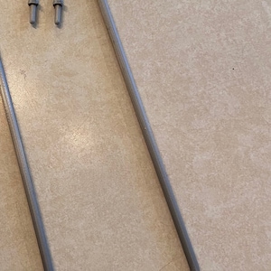 May include: A gray plastic support bracket with three small holes at the top.