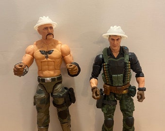 May include: Two action figures wearing white hard hats. The figure on the left has a bare chest with a black and white tattoo. Both figures are wearing camouflage pants and boots.