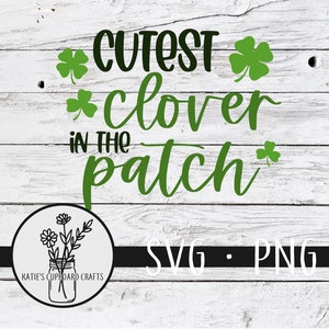 May include: Green clover leaf graphic with the text "Cutest clover in the patch" and the words "SVG - PNG" on a white wood background.