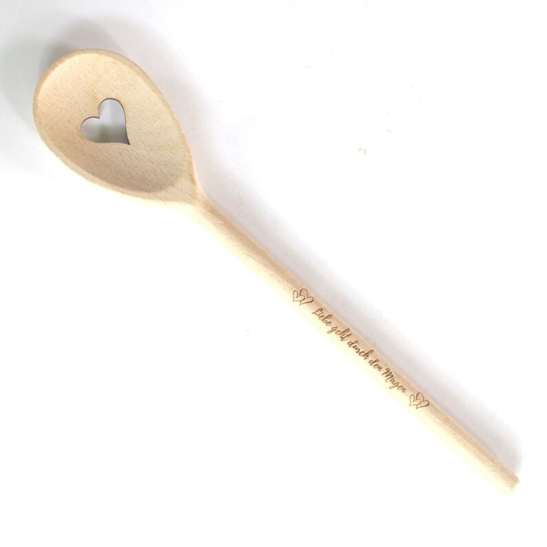 Op de afbeelding: Een houten lepel met een hartvormige uitsparing en de inscriptie "Liebe geht durch den Magen" (Liefde gaat door de maag) in het Duits.