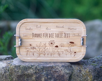 May include: A wooden lunchbox with a floral design and the text "Danke für die tolle Zeit" (Thank you for the great time). The lunchbox has metal clasps and is engraved with the names Sandra, Emil, Klaus, Hannah, Martina, Lars, and Claudia.