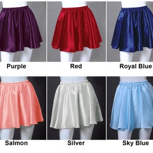 Puede incluir: Seis faldas cortas de satén en diferentes colores: morado, rojo, azul real, salmón, plateado y azul cielo. Las faldas son todas del mismo estilo, con cintura elástica y vuelo.