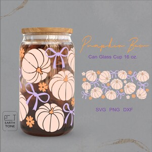 Könnte beinhalten: Ein klares Glas in Dosenform mit Holzdeckel, verziert mit hellorangen Kürbissen, lila Schleifen und orangefarbenen Blumen. Der Text "Pumpkin Bam" und "Can Glass Cup 16 oz." sind sichtbar. Das Design umfasst SVG-, PNG- und DXF-Formate.