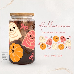 Puede incluir: Un vaso de vidrio transparente con tapa de madera, decorado con ilustraciones temáticas de Halloween. El diseño incluye fantasmas de dibujos animados, calabazas y lazos en crema, rosa y naranja. También se ve el texto "Halloween".