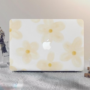 May include: A white laptop case with a floral design. The flowers are yellow and white and have a watercolour effect. The Apple logo is visible on the case.