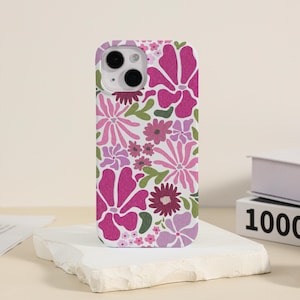 Könnte beinhalten: Eine weiße Handyhülle mit einem pink- und lilafarbenen Blumenmuster. Die Hülle hat einen Ausschnitt für die Kamera.