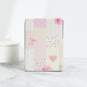 以下が含まれることがあります： ピンクと白のパッチワークタブレットケース。花柄とリボンのデザイン。ギンガムチェック、花柄プリント、ハートなど、さまざまなパターンがあります。ピンクの花が取り付けられています。